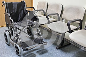 Wheel chair stands in lobby of hospital ready to photo