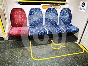 Wheel chair and vision impaired passengers in the designated wheelchair space on a train.