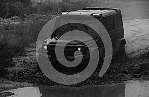 Wheel close up in a countryside landscape with a muddy road. Off-road 4x4 concept. Low angle view of front of SUV on