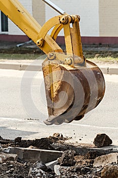 Wheel excavator digging trench on rocky land