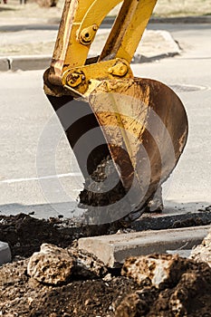 Wheel excavator digging trench on rocky land