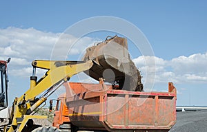 Wheel excavator loading gravel pile