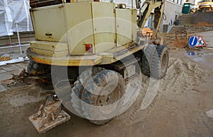 Wheel excavator machine unloading sand at eathmoving works in construction site. Old wheel excavator after work