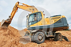 Wheel excavator at sandpit during earthmoving works photo
