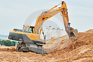 Wheel excavator at sandpit during earthmoving works photo