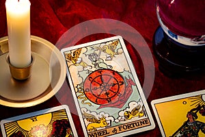 Wheel of fortune card and crystal ball under candle light. Cartomancy is fortune telling using cards, while scrying and photo