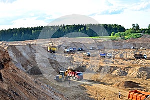 Wheel front-end loader loads sand into a dump truck. Heavy machinery in the mining quarry, excavators and trucks. Mobile jaw