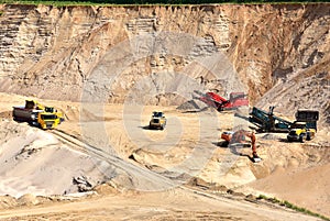 Wheel front-end loader loads sand into a dump truck. Heavy machinery in the mining quarry, excavators and trucks. Mobile jaw