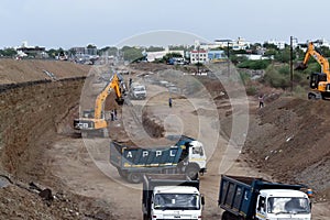 Wheel front-end loader unloading sand into heavy dump truck. Crushing factory, machines and equipment for crushing, grinding stone