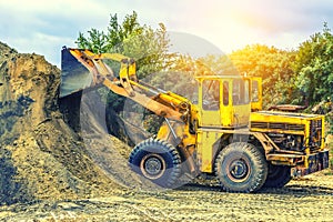 Wheel loader Excavator with backhoe loading sand at eathmoving works in construction site