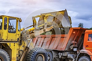 Wheel loader excavator with backhoe unloading clay