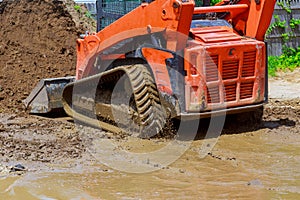 Wheel loader Excavator with backhoe unloading earth at eathmoving works construction site quarry