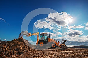 Wheel loader excavator with field background during earthmoving work, construction building photo