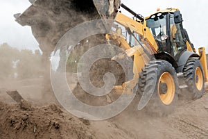 Wheel loader Excavator unloading sand and soil with dust