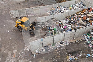 Wheel loader with lifted scrap grapple moving along a recycling center