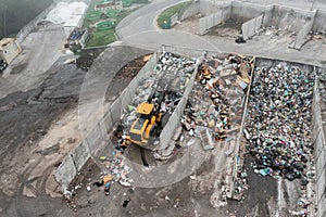 Wheel loader with lifted scrap grapple moving along a recycling center