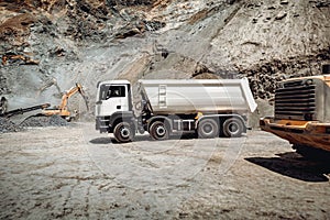 Wheel loader loading gravel into dumper trucks. Industry details - machinery working