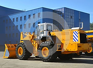 Wheel loader machine for handling bulk materials in an open pit or construction site. Heavy quarry equipment with bucket. Heavy