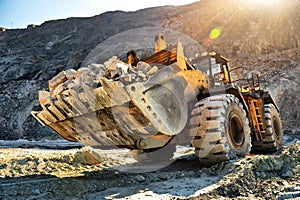 Wheel loader machine unloading rocks in the open-mine