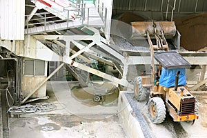 Wheel loader machine unloading sand in construction site, construction