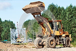 Wheel loader machine unloading sand at eathmoving works at construction site