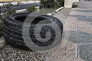 A wheel lying on the sidewalk.