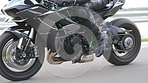 Wheel of modern sport motorbike riding fast at highway. Motorcycle driving at asphalt route. Motor bike racing on