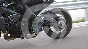Wheel of modern sport motorbike riding fast at highway. Motorcycle driving at asphalt route. Motor bike racing on