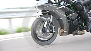 Wheel of modern sport motorbike riding fast at highway. Motorcycle driving at asphalt route. Motor bike racing on