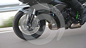 Wheel of modern sport motorbike riding fast at highway. Motorcycle driving at asphalt route. Motor bike racing on