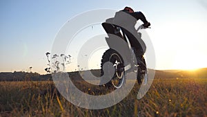 Wheel of motocross bike starting to spin and kicking up ground or dirt. Motorcycle beginning the movement. Motorcyclist