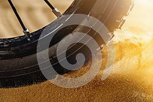 Wheel mountain bike bicycle detail in a sunny day and flying motion sand