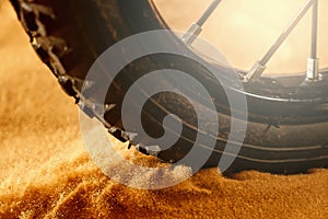 Wheel mountain bike bicycle detail in a sunny day and flying motion sand