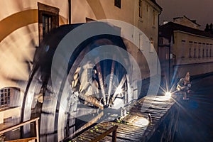 Wheel of an old watermill in the middle of Prague spinning at night with intentional motion blur