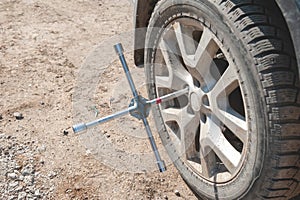 Wheel replacement on the road by the driver. Replacing summer tires with winter tires with a handy wrench by a mechanic