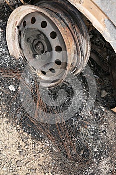 Wheel rim of burnt out car on the side of a road