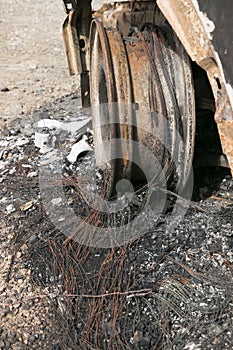 Wheel rim of burnt out car on the side of a road