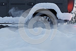 Wheel spinning of car tires stucked in snow