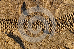 Wheel tires grooves in the golden beach sand