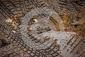 Wheel track on dirt ground mud over puddle