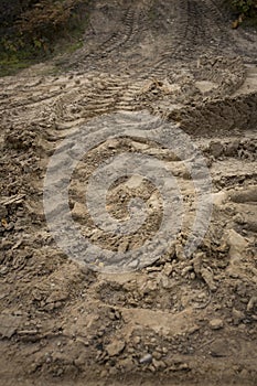 Wheel trail on sandy ground from large transport, tractor on construction site, sandy road