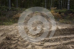 Wheel trail on sandy ground from large transport, tractor on construction site, sandy road