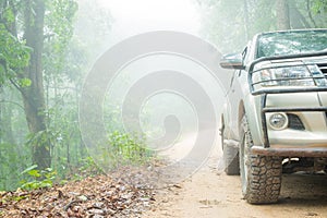 Wheel truck closeup in countryside landscape with muddy road. Extreme adventure driving 4x4 vehicles for transport or travel or