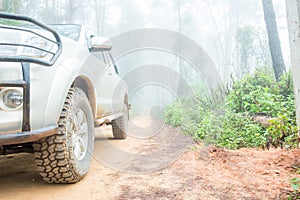 Wheel truck closeup in countryside landscape with muddy road. Extreme adventure driving 4x4 vehicles for transport or travel or