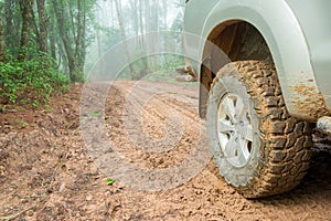 Wheel truck closeup in countryside landscape with muddy road. Extreme adventure driving 4x4 vehicles for transport or travel or