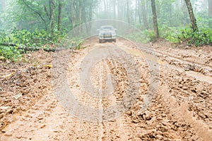 Wheel truck closeup in countryside landscape with muddy road. Extreme adventure driving 4x4 vehicles for transport or travel or