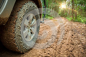 Wheel truck closeup in countryside landscape with muddy road. Extreme adventure driving 4x4 vehicles for transport or travel or