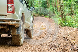 Wheel truck closeup in countryside landscape with muddy road. Extreme adventure driving 4x4 vehicles for transport or travel or