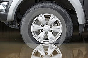 A wheel of a truck on a flooded road