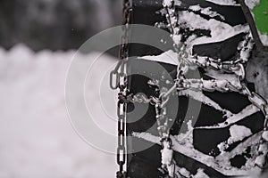 Wheel of a truck with snow chains mounted on it for a better grip